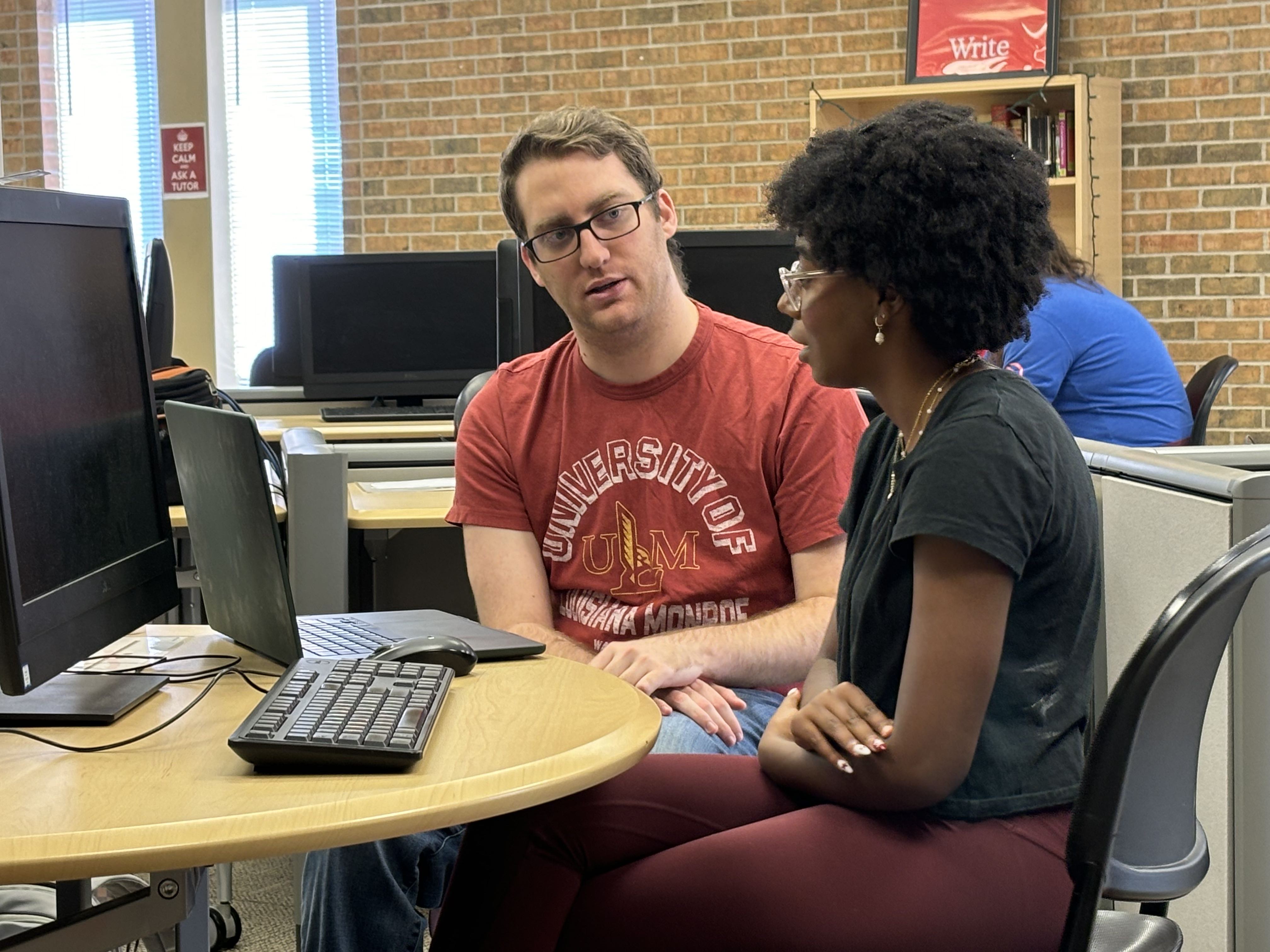 Garrett, a writing coach, helps a student