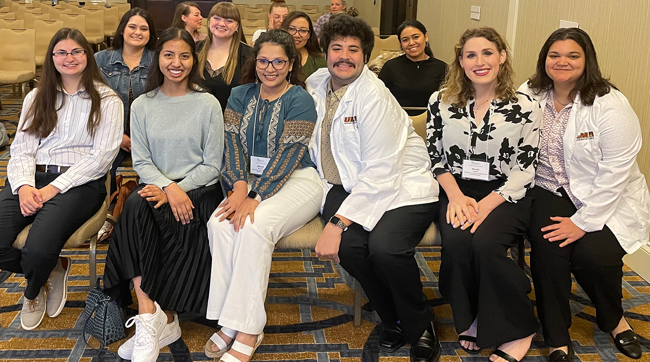 A group of seated students smile at the camera.